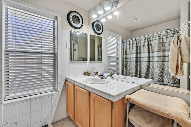 bathroom with tile walls, vanity, and tile patterned floors