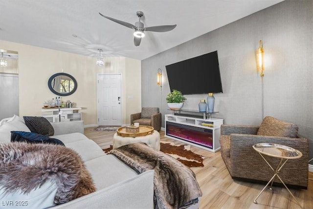 living room with ceiling fan and light hardwood / wood-style flooring