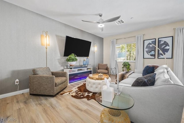 living room with light wood-type flooring and ceiling fan