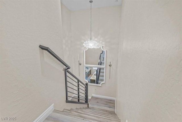 stairs featuring an inviting chandelier and hardwood / wood-style floors