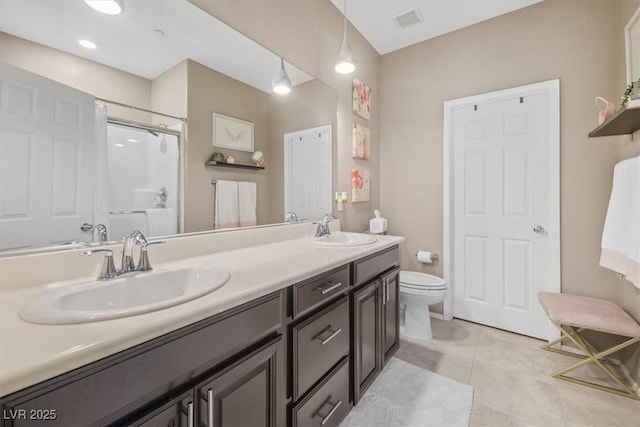 bathroom featuring toilet, a shower, vanity, and tile patterned floors