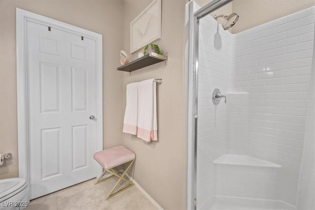 bathroom featuring toilet, tile patterned flooring, and a shower with shower door