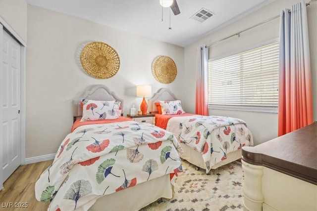 bedroom with ceiling fan, a closet, and wood-type flooring