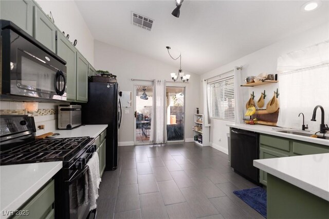 kitchen with sink, green cabinetry, vaulted ceiling, black appliances, and a notable chandelier