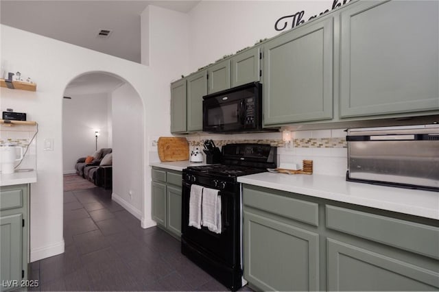 kitchen featuring black appliances, backsplash, and green cabinets