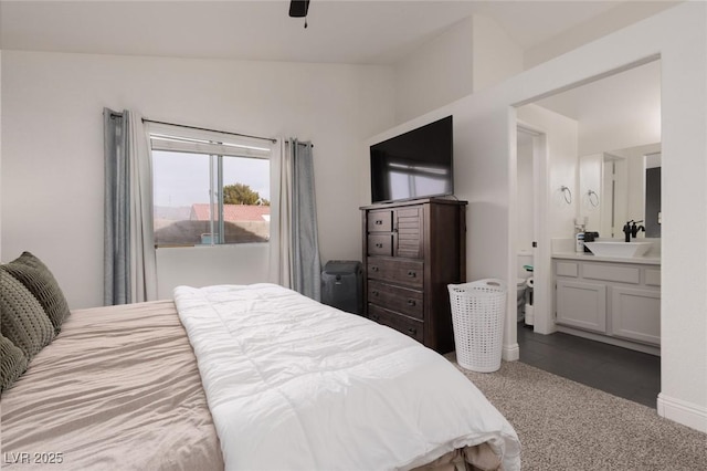 carpeted bedroom with vaulted ceiling, ensuite bath, ceiling fan, and sink