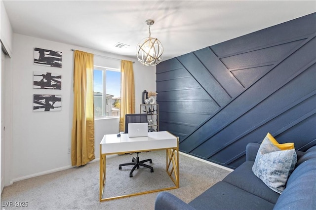 carpeted home office featuring an inviting chandelier