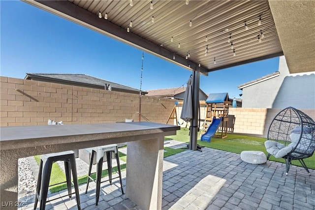 view of patio / terrace with a playground and exterior bar