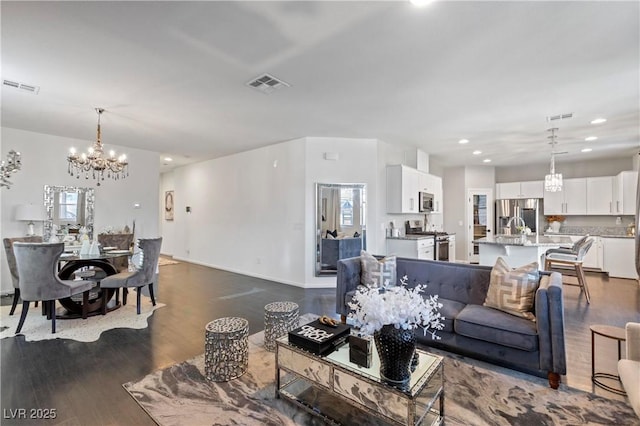 living room with dark hardwood / wood-style flooring and a chandelier