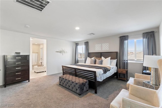 carpeted bedroom featuring ensuite bathroom and multiple windows