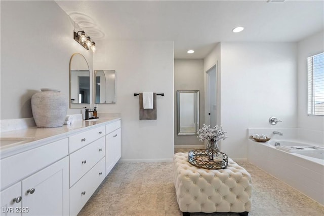 bathroom with vanity and a relaxing tiled tub