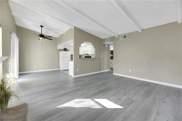 unfurnished living room with ceiling fan, light hardwood / wood-style floors, lofted ceiling with beams, and a textured ceiling