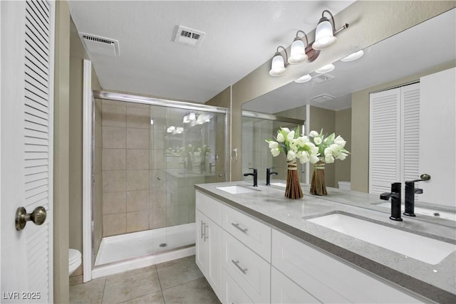 bathroom with toilet, an enclosed shower, vanity, and tile patterned flooring