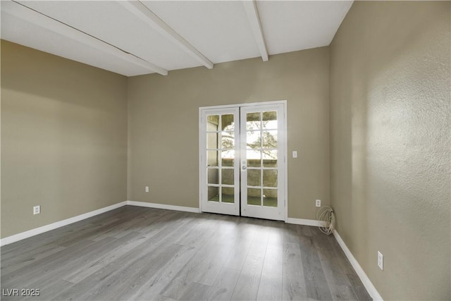 unfurnished room with wood-type flooring and beam ceiling