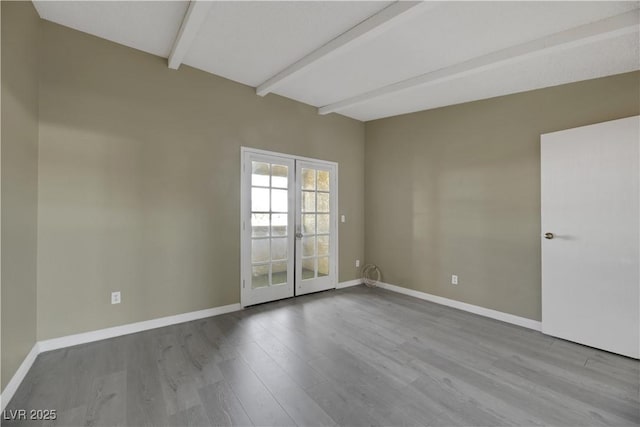 empty room with light wood-type flooring, beam ceiling, and french doors