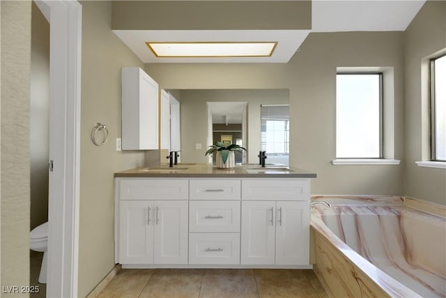 bathroom with a bathing tub, tile patterned flooring, vanity, and toilet