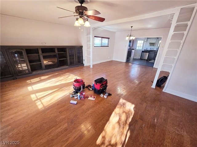 unfurnished living room with ceiling fan with notable chandelier and hardwood / wood-style floors