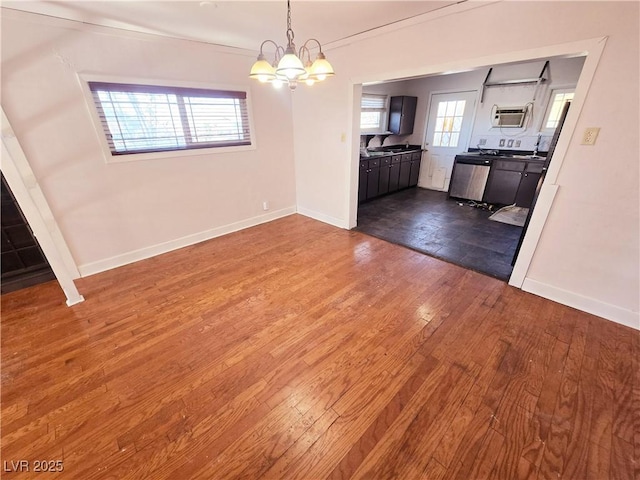 unfurnished dining area with a healthy amount of sunlight, an inviting chandelier, and dark hardwood / wood-style flooring