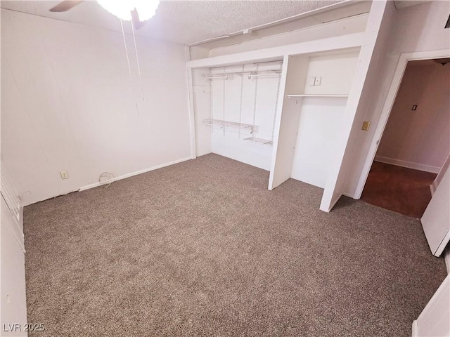 unfurnished bedroom with ceiling fan, dark carpet, and a closet