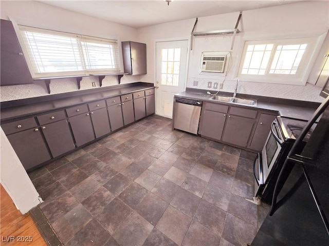 kitchen featuring sink, gray cabinetry, range, stainless steel dishwasher, and a wall unit AC