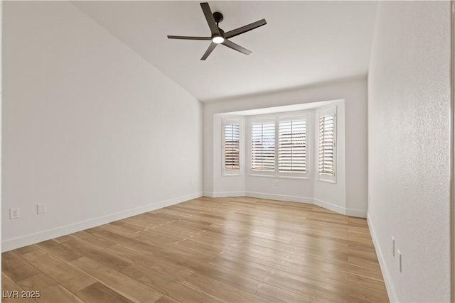 empty room featuring ceiling fan, light wood-type flooring, and vaulted ceiling