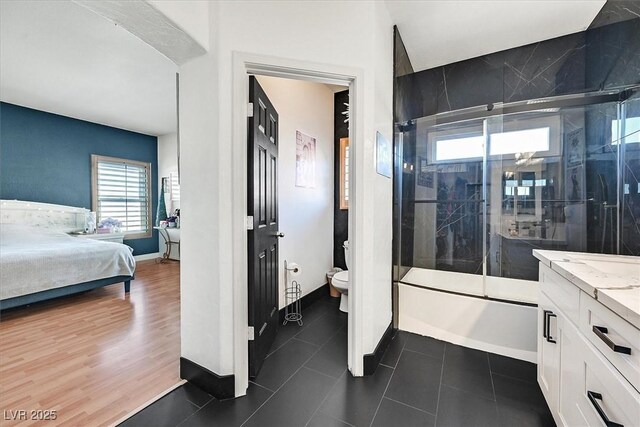 full bathroom with toilet, tile patterned flooring, shower / bath combination with glass door, and vanity