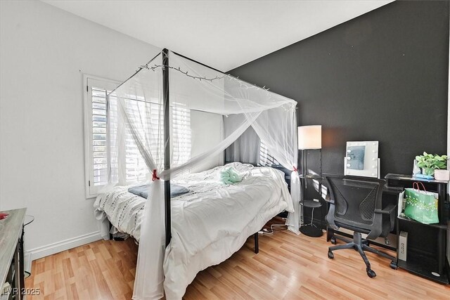 bedroom featuring multiple windows and hardwood / wood-style floors