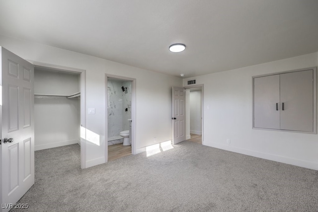 unfurnished bedroom featuring light colored carpet and ensuite bath