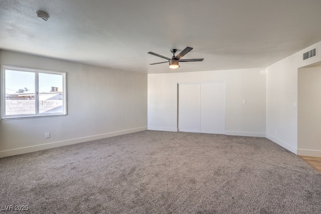 carpeted spare room featuring ceiling fan