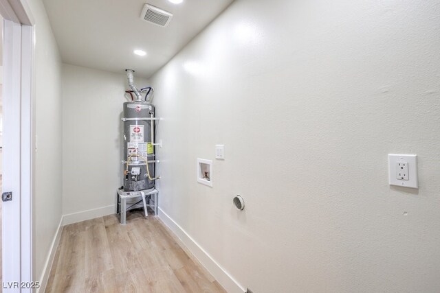 laundry room with water heater, washer hookup, light wood-type flooring, and hookup for an electric dryer