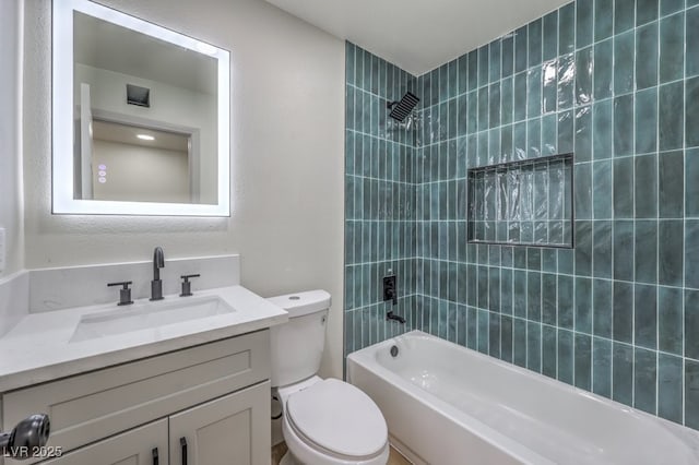 full bathroom with toilet, vanity, and tiled shower / bath