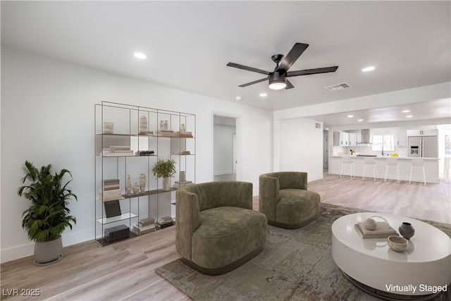 living room featuring light wood-type flooring and ceiling fan