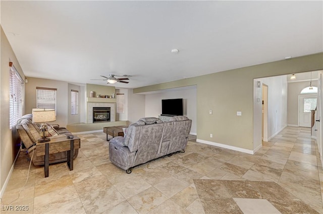 living room featuring ceiling fan and a fireplace