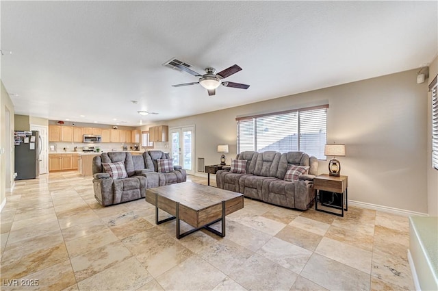 living room with a textured ceiling and ceiling fan