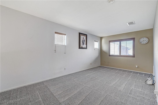 spare room featuring plenty of natural light and light colored carpet