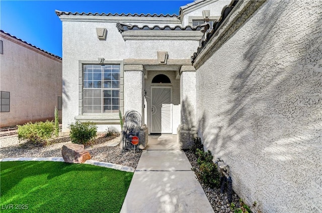 entrance to property featuring a lawn