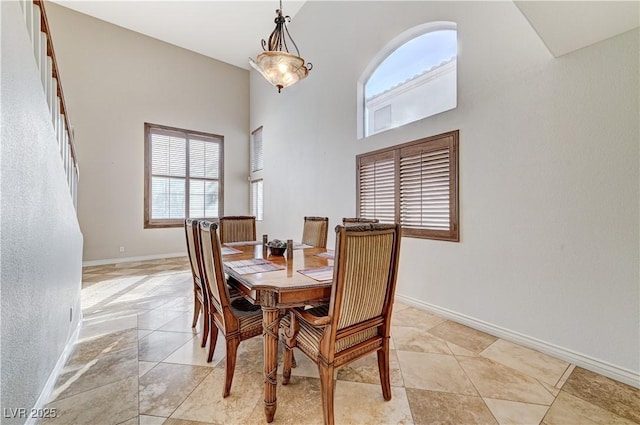 tiled dining space with a towering ceiling