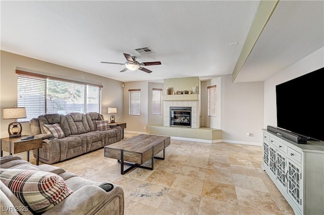 living room with a fireplace and ceiling fan