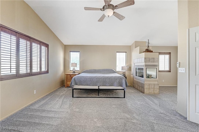 bedroom with lofted ceiling, a fireplace, ceiling fan, and light colored carpet