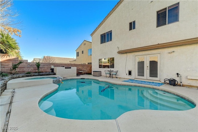 view of swimming pool featuring french doors and an in ground hot tub