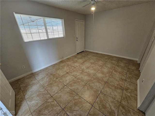 empty room featuring a textured ceiling, ceiling fan, and light tile patterned floors