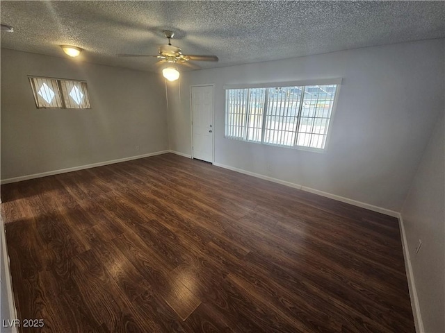 unfurnished room with a textured ceiling, ceiling fan, and dark wood-type flooring