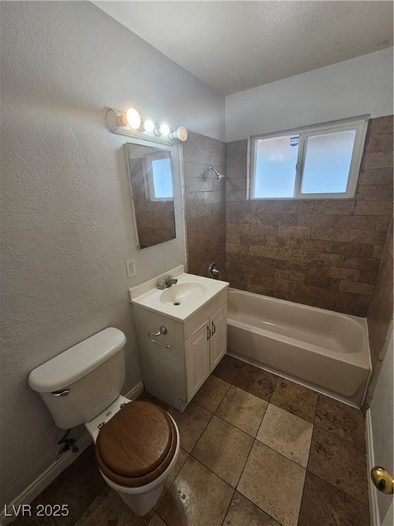 full bathroom with vanity, toilet, plenty of natural light, and tiled shower / bath