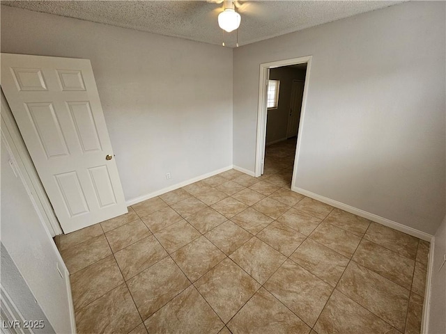 tiled spare room featuring a textured ceiling and ceiling fan