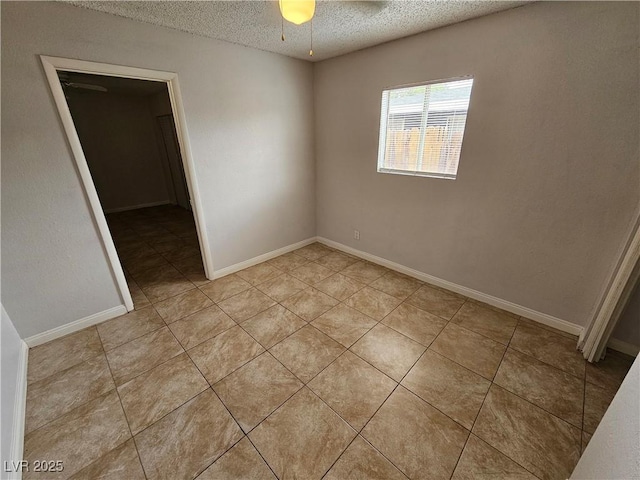 tiled empty room featuring a textured ceiling and ceiling fan