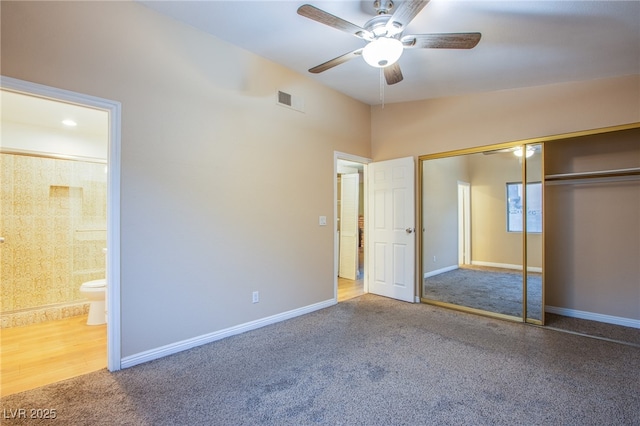 unfurnished bedroom featuring vaulted ceiling, a closet, connected bathroom, carpet flooring, and ceiling fan