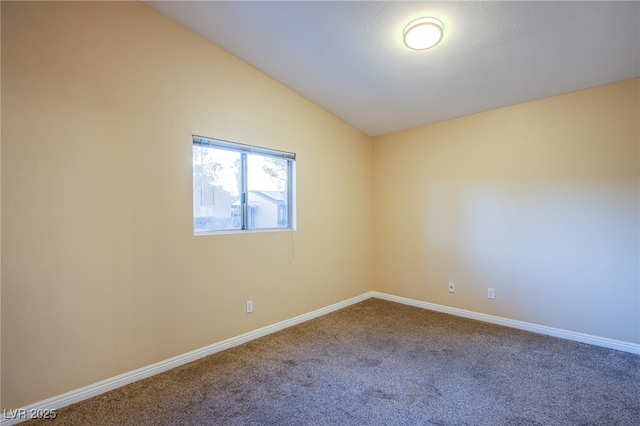 empty room with carpet floors and vaulted ceiling