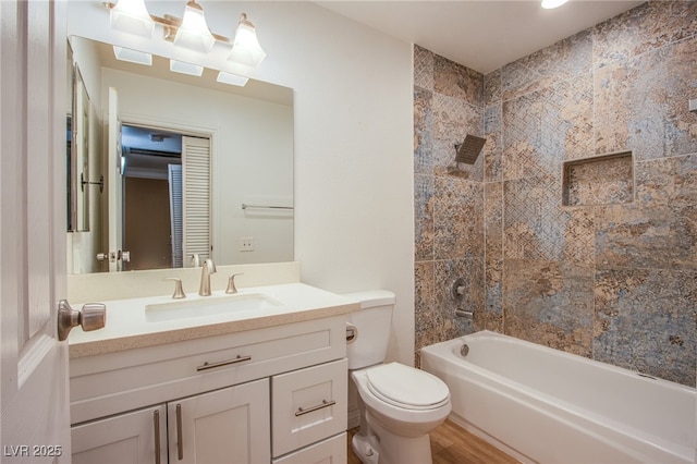 full bathroom featuring toilet, wood-type flooring, vanity, and tiled shower / bath