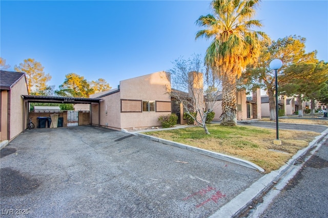 view of front of property featuring a carport and a front lawn