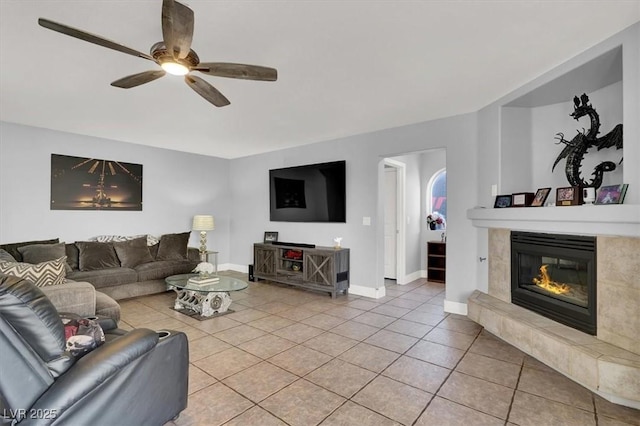 living room featuring light tile patterned flooring, a fireplace, and ceiling fan